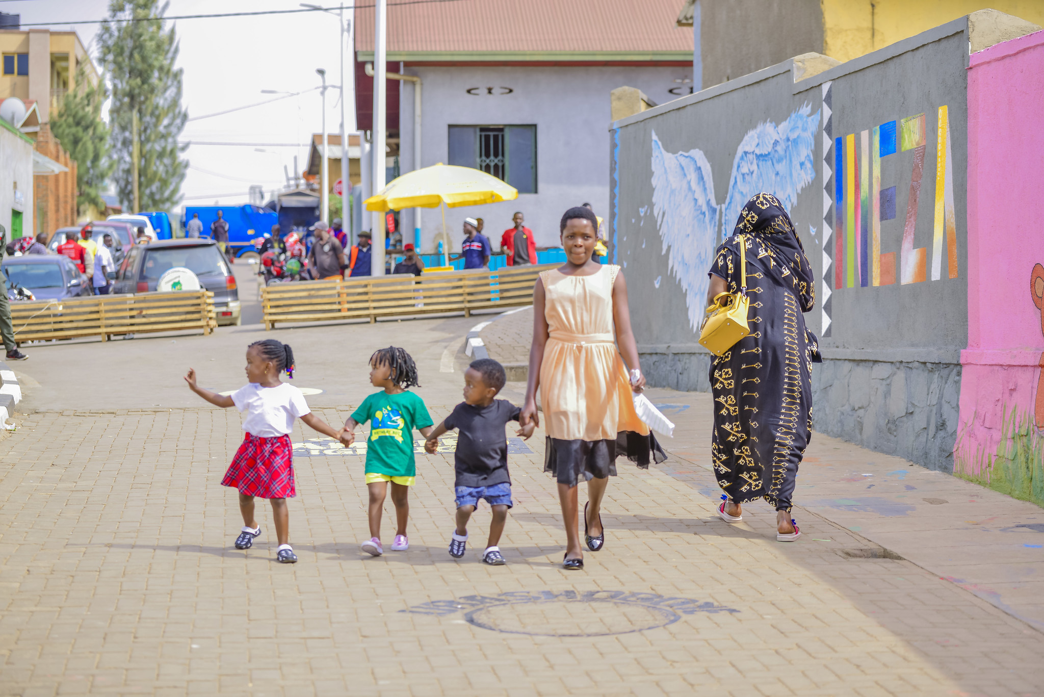 Fille et enfants marchant dans une rue piétonne à Kigali, au Rwanda.
