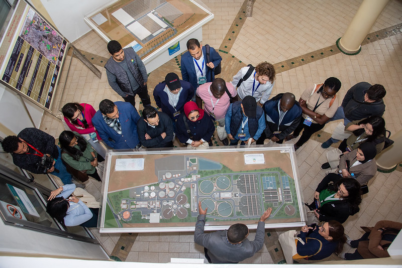 Une vue aérienne des participants de la Marrakech City Academy regardant un diorama de la ville