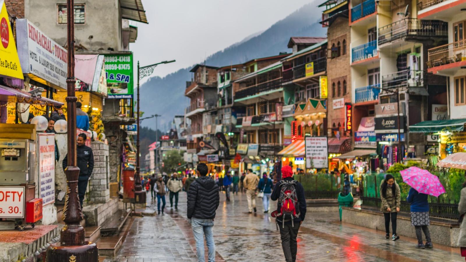 Piétons marchant sur un trottoir dans une ville indienne.