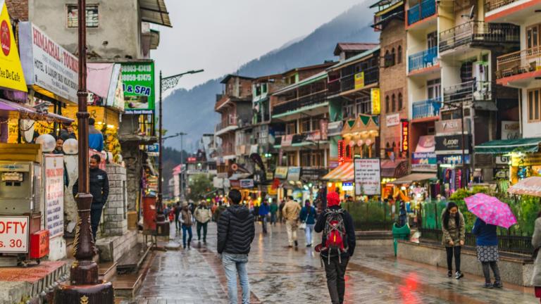 Piétons marchant sur un trottoir dans une ville indienne.