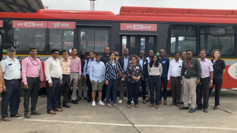Les participants à l'échange Peer to Peer du site UrbanShift devant un bus à émission zéro à Mumbai