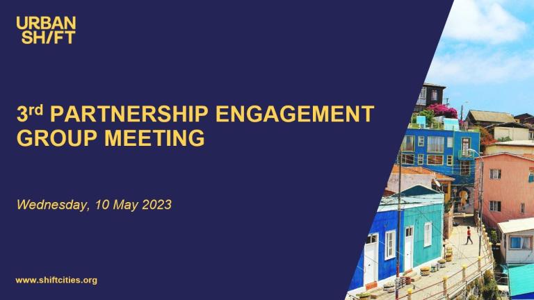 une diapositive sur laquelle on peut lire 3e réunion du groupe d'engagement du partenariat sur un fond bleu marine ; une image de bâtiments aux couleurs vives se trouve à droite.