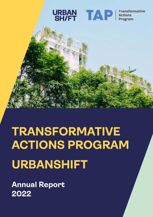 La couverture du rapport annuel du programme d'actions transformatrices UrbanShift 2022. La photographie d'un bâtiment avec des arbres en façade est bordée de blocs jaunes, bleus et verts pâles.